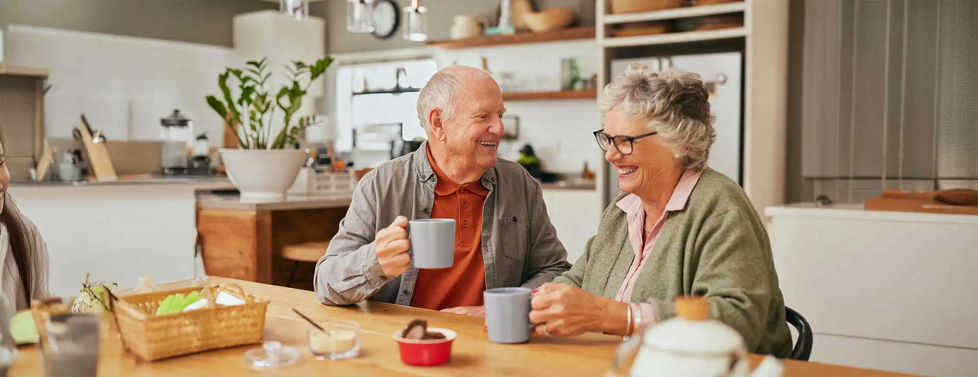 An elderly man and woman sit at a kitchen table, smiling and holding mugs, with breakfast items and tableware in front of them—just like the cozy scenes often featured in our FAQ or Frequently Asked Questions section. An elderly man and woman sit at a kitchen table, smiling and holding mugs, with breakfast items and tableware in front of them—just like the cozy scenes often featured in our FAQ or Frequently Asked Questions section.